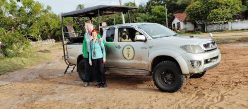 two women standing next to a white truck with a golf cart at Scoop Cabana Kitesurfing in Kalpitiya