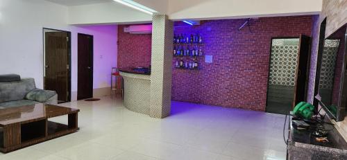 a living room with a brick wall and purple lighting at Gotawala Villa 16 in Daman