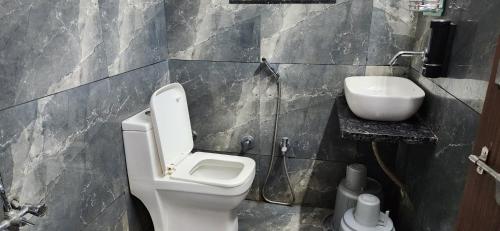 a bathroom with a toilet and a sink at Gotawala Villa 16 in Daman