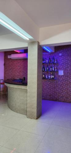 a room with a brick wall and a counter with purple lights at Gotawala Villa 16 in Daman