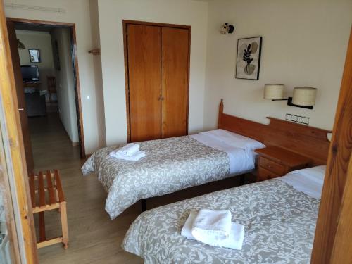 a hotel room with two beds with towels on them at Apartamento de la Marmota Cerler in Cerler
