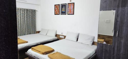 two beds in a room with white walls at Gotawala Villa 16 in Daman
