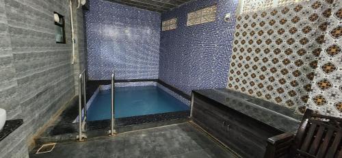 a bath tub in a bathroom with blue tiles at Gotawala Villa 16 in Daman
