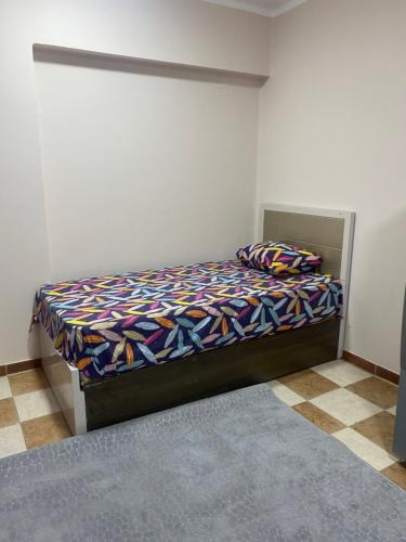 a bedroom with a bed with a colorful comforter at Asyut Cozy Nile view apartment in Asyut