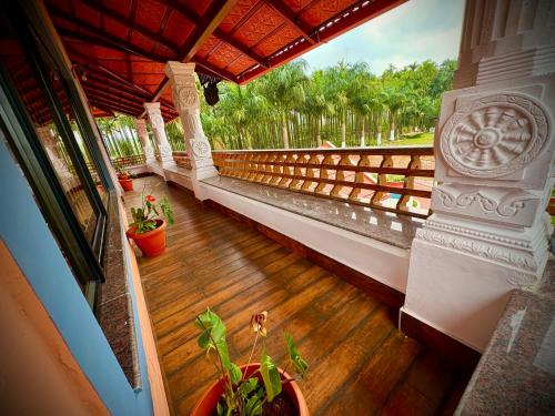 a balcony of a house with a wooden floor and plants at Haveli Holiday Home in Mudigere
