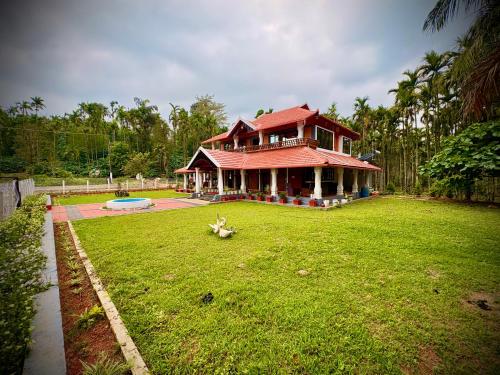 a house with a green yard in front of it at Haveli Holiday Home in Mudigere