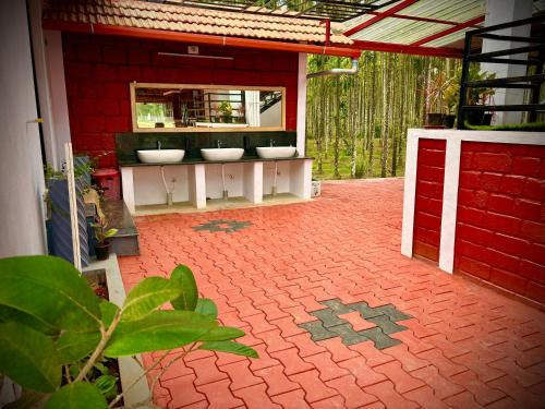 a bathroom with three sinks in a red building at Haveli Holiday Home in Mudigere