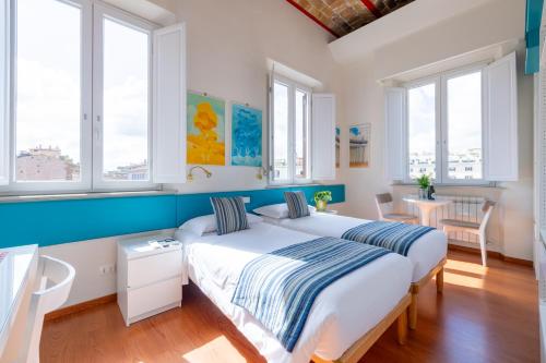 two beds in a room with two windows at Superior Relais FCollection Temple View in Rome