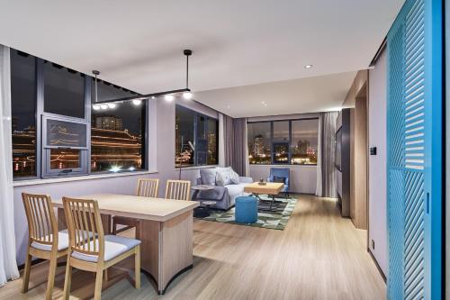 a living room with a table and chairs and a couch at Country Inn&Suites By Radisson, Xi'an Bell and Drum Tower Flagship in Xi'an