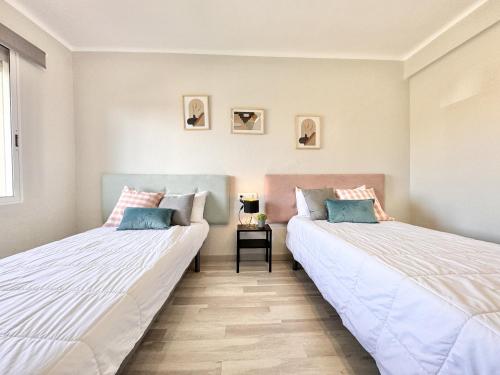 two beds sitting next to each other in a room at Mediterranean Way - Pineda 1 in La Pineda