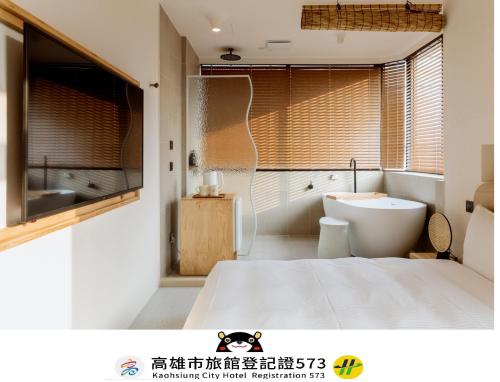 a bathroom with a bed and a tub and a toilet at Just Inn Kaohsiung in Kaohsiung