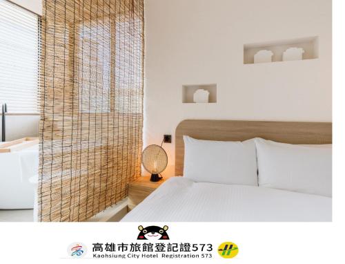 a bedroom with a white bed and a window at Just Inn Kaohsiung in Kaohsiung