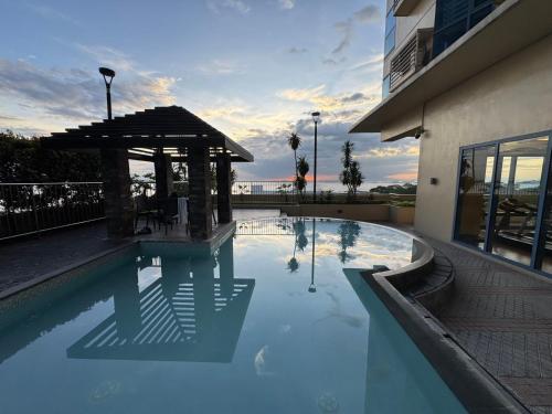 a swimming pool with a gazebo next to a building at Beachfront U.S. Embassy Family Retreat. in Manila