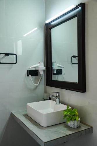 a bathroom with a white sink and a mirror at Clear Point Studio in Dickwella