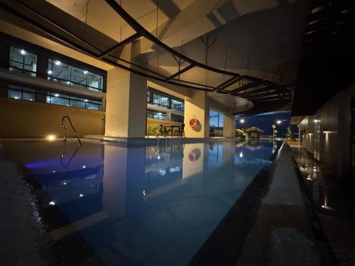 a swimming pool in a building at night at Beachfront U.S. Embassy Family Retreat. in Manila
