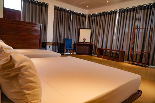 a hotel room with two beds and a mirror at Clear Point Studio in Dickwella
