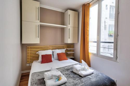 - une chambre avec un lit avec deux oreillers et une fenêtre dans l'établissement Bluestay 176 - Superbe Appartement à Paris, à Paris