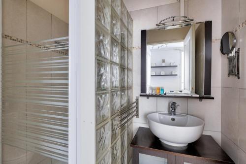 une salle de bain avec un lavabo et un miroir dans l'établissement Bluestay 176 - Superbe Appartement à Paris, à Paris