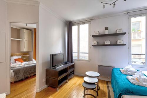 une petite chambre avec un lit et une télévision dans l'établissement Bluestay 176 - Superbe Appartement à Paris, à Paris