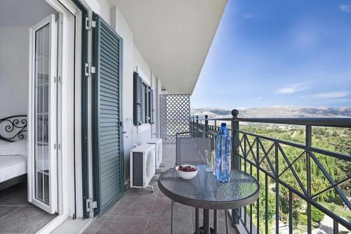 a balcony with a table and a view of the mountains at Monte Verde apartments in Lixouri
