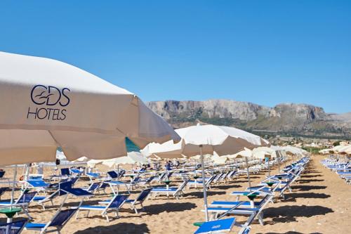a bunch of chairs and umbrellas on a beach at CDSHotels Terrasini - Città del Mare in Terrasini