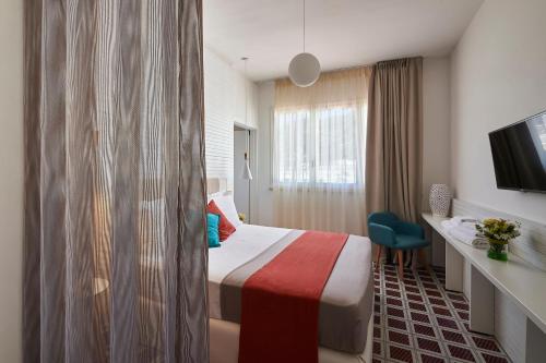 a hotel room with a bed and a desk and a tv at Grand Hotel Riviera - CDSHotels in Santa Maria al Bagno