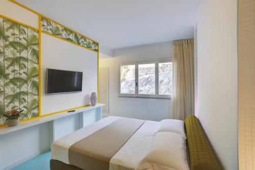 a bedroom with a bed and a tv and a window at Grand Hotel Riviera - CDSHotels in Santa Maria al Bagno