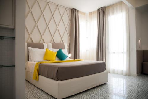 a bedroom with a large bed with yellow and blue pillows at Grand Hotel Riviera - CDSHotels in Santa Maria al Bagno