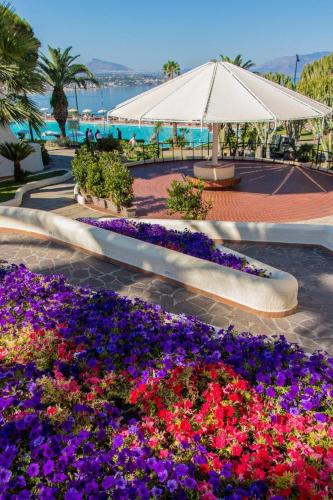 a garden with purple and purple flowers in a park at CDSHotels Terrasini - Città del Mare in Terrasini