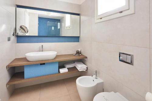 a bathroom with a sink and a toilet and a mirror at Grand Hotel Riviera - CDSHotels in Santa Maria al Bagno
