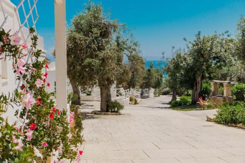a walkway with trees and flowers on the side of a building at Marenea Suite Hotel - CDSHotels in Marittima