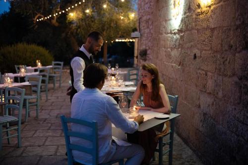 a group of people sitting at a table in a restaurant at Marenea Suite Hotel - CDSHotels in Marittima