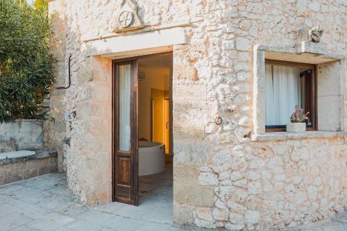 a stone building with a door and a window at Marenea Suite Hotel - CDSHotels in Marittima