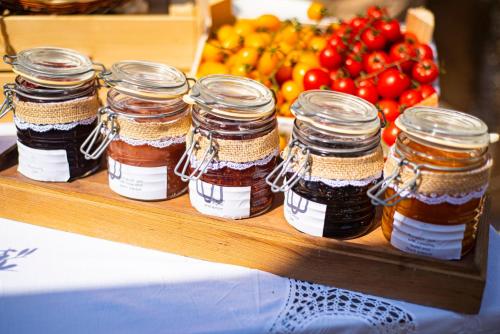 a group of jars of jam on a table with fruit at Marenea Suite Hotel - CDSHotels in Marittima