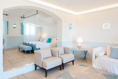 a bedroom with two beds and two chairs at Marenea Suite Hotel - CDSHotels in Marittima