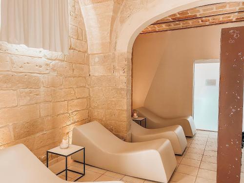 a waiting room with chairs and a brick wall at Relais Masseria Le Cesine - CDSHotels in Vernole