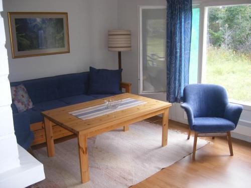 a living room with a blue couch and a wooden table at Tornvillan in Hammarland