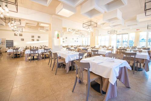 a dining room with white tables and chairs at Relais Masseria Le Cesine - CDSHotels in Vernole