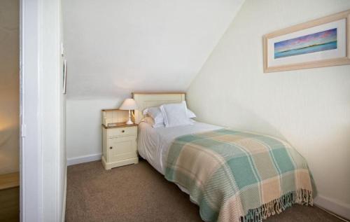 a small bedroom with a bed and a night stand at Bardristane Forge in Gatehouse of Fleet