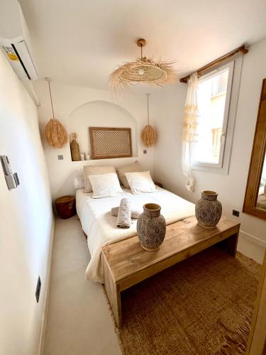 une chambre avec un lit et deux vases sur une table dans l'établissement Séjour marseillais - Penthouse vieux port climatisé, à Marseille