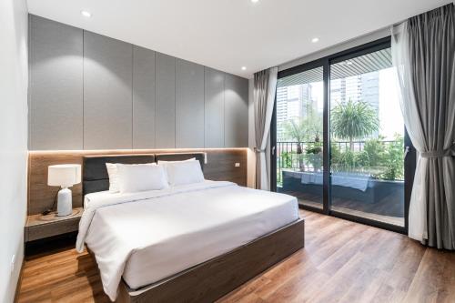 a bedroom with a large bed and a large window at Luxe Paradise Suites Hotel To Ngoc Van in Hanoi