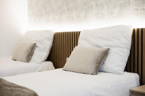two white pillows sitting on top of a bed at GOŚCINIEC ZACISZE - pokoje & restauracja blisko A2 Dąbie - Uniejów in Dąbie