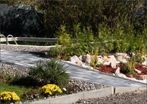 a garden with a wooden walkway and plants at Wellness Borealis in Tuzla