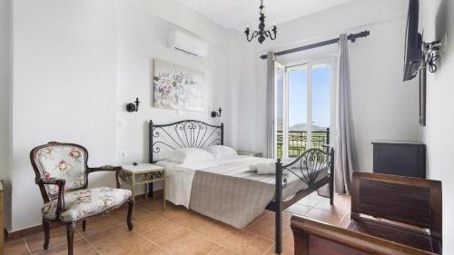 a bedroom with a bed and a chair and a window at Monte Verde apartments in Lixouri
