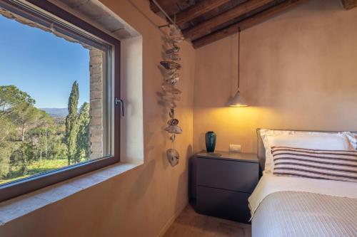 Un dormitorio con una cama y una ventana con vistas. en Donna Tosca Country Holiday Home, en Suvereto