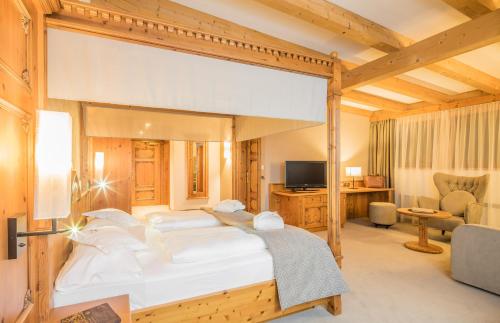 a bedroom with a large bed in a room at Savoy Dolomites Luxury & Spa Hotel in Selva di Val Gardena