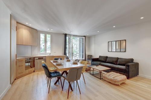 une cuisine et un salon avec une table et un canapé dans l'établissement Bluestay 846 - Superbe appartement, à Paris