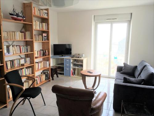 un salon avec un canapé, des chaises et une télévision dans l'établissement Appartement VUE SUR MER, wifi, plage du Coz-Pors à TREGASTEL - Réf 610, à Trégastel