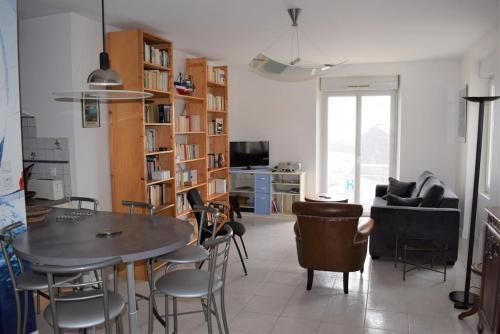 un salon avec une table, des chaises et un canapé dans l'établissement Appartement VUE SUR MER, wifi, plage du Coz-Pors à TREGASTEL - Réf 610, à Trégastel