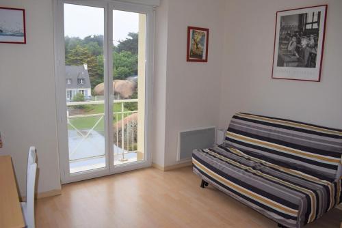 un salon vide avec une porte coulissante en verre dans l'établissement Appartement VUE SUR MER, wifi, plage du Coz-Pors à TREGASTEL - Réf 610, à Trégastel